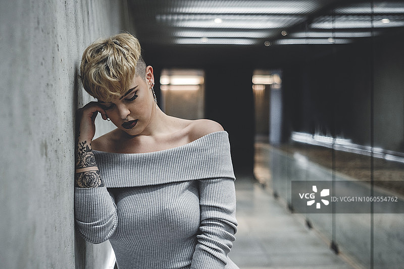 城市水泥通道中孤独的年轻女子图片素材