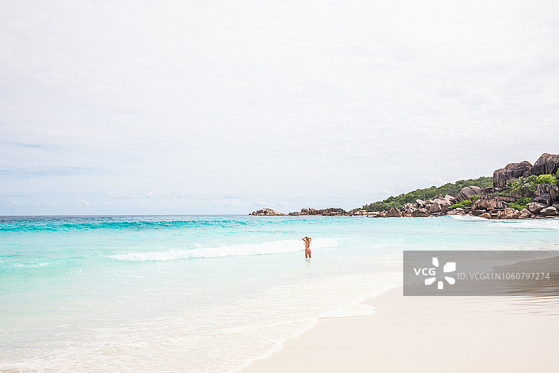 塞舌尔拉迪格岛海滩与戏水女人全景图片素材