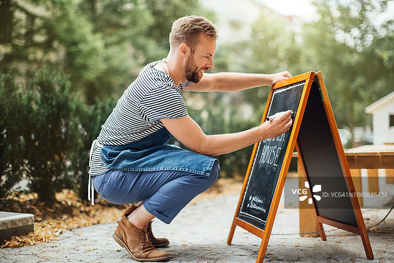 咖啡师在黑板上写今日特价图片素材