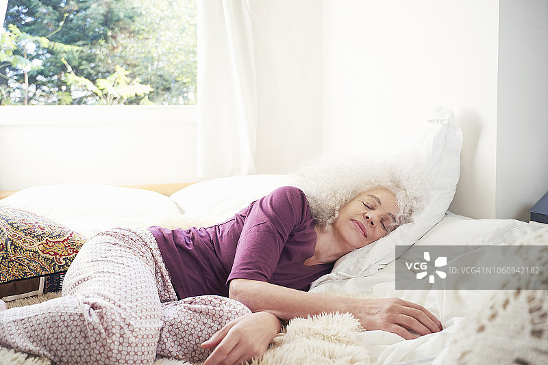 在床上睡觉的年长女性图片素材