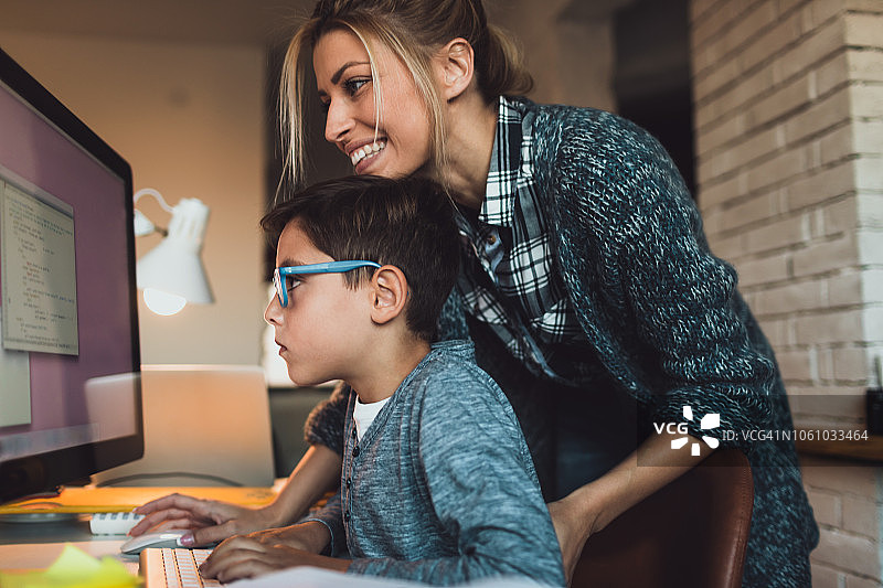 妈妈在家帮助小学生编写电脑程序图片素材