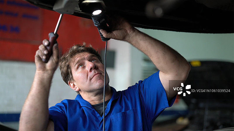 专业技工在汽车修理店修理汽车 - 小型企业图片素材