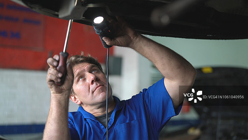 专业技工在汽车修理店修理汽车 - 小型企业图片素材
