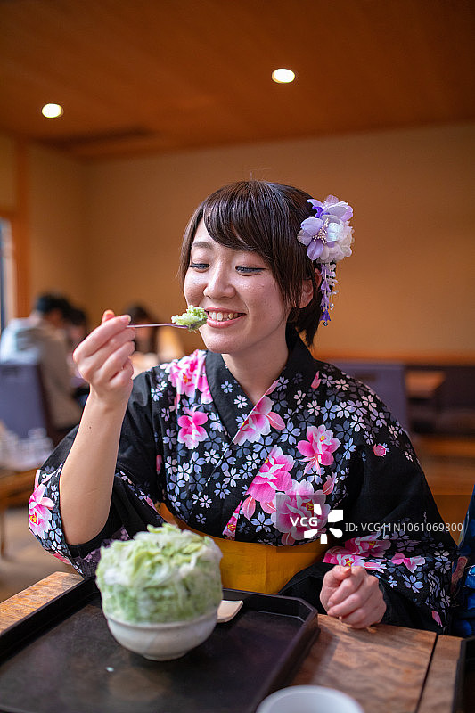 年轻女子在咖啡馆里穿着浴衣吃刨冰图片素材