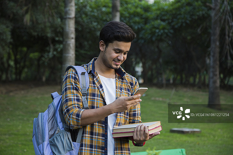 户外手捧书本的男大学生图片素材