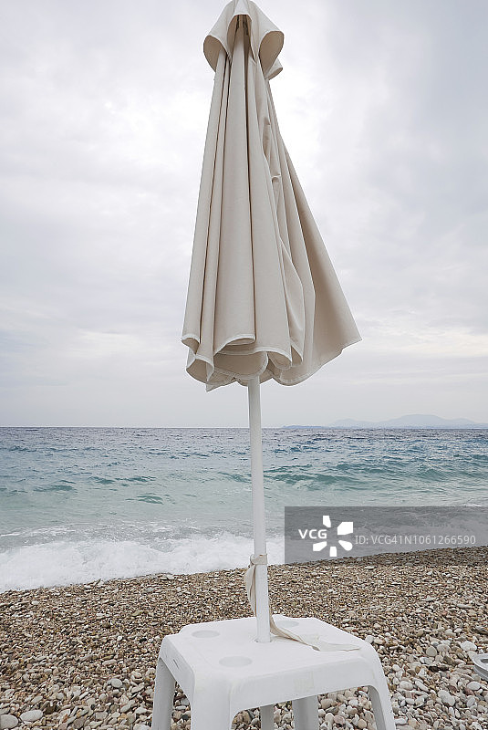 鹅卵石海滩上折叠的沙滩伞图片素材