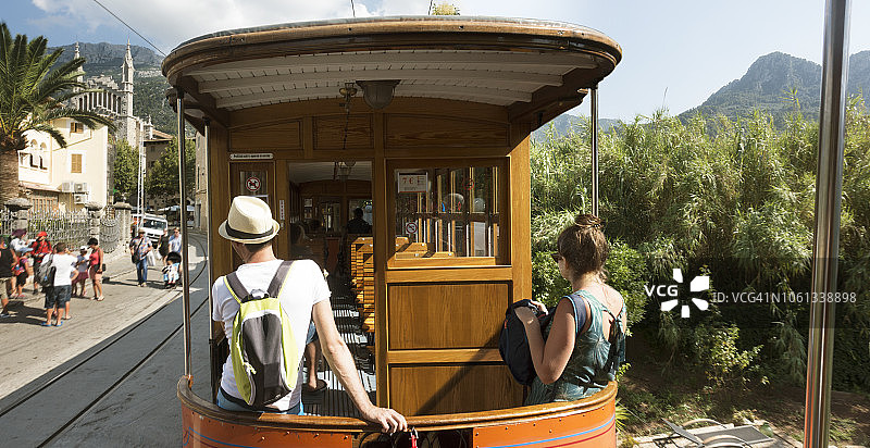 年轻夫妇坐在穿梭于城镇的火车尾部图片素材
