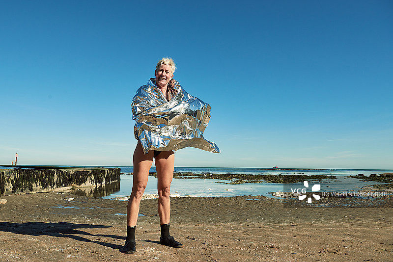 在海里游泳后，裹着锡箔毯子的女人肖像图片素材