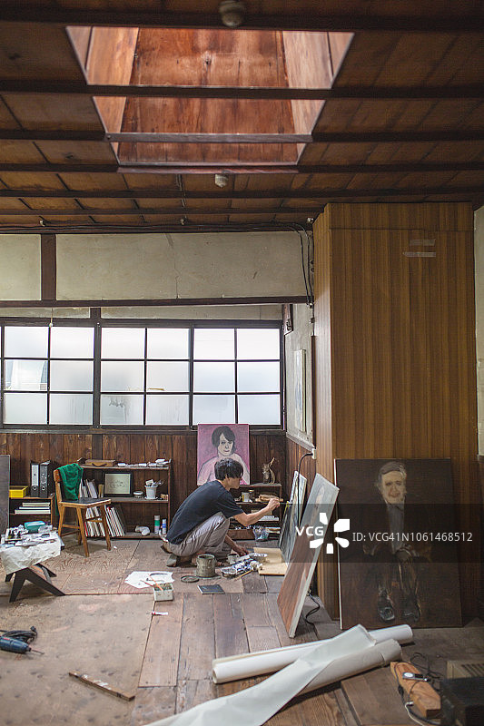 男艺术家在他的工作室里用油画颜料绘画图片素材