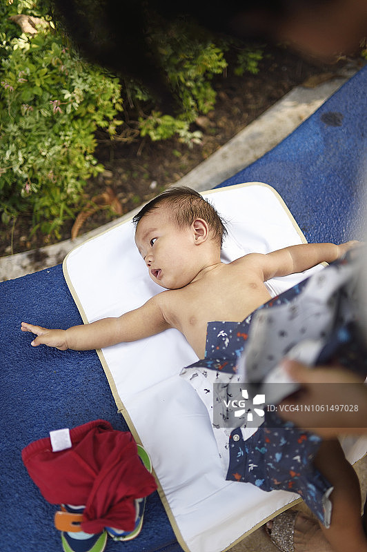 妈妈在户外给宝宝换尿布图片素材