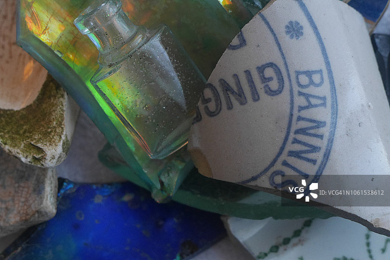 在伦敦泰晤士河的泥泞中发现的彩虹色玻璃陶器和古董香水瓶碎片图片素材