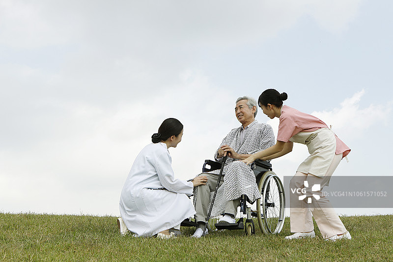 医生和护士帮助乘坐轮椅的病人图片素材