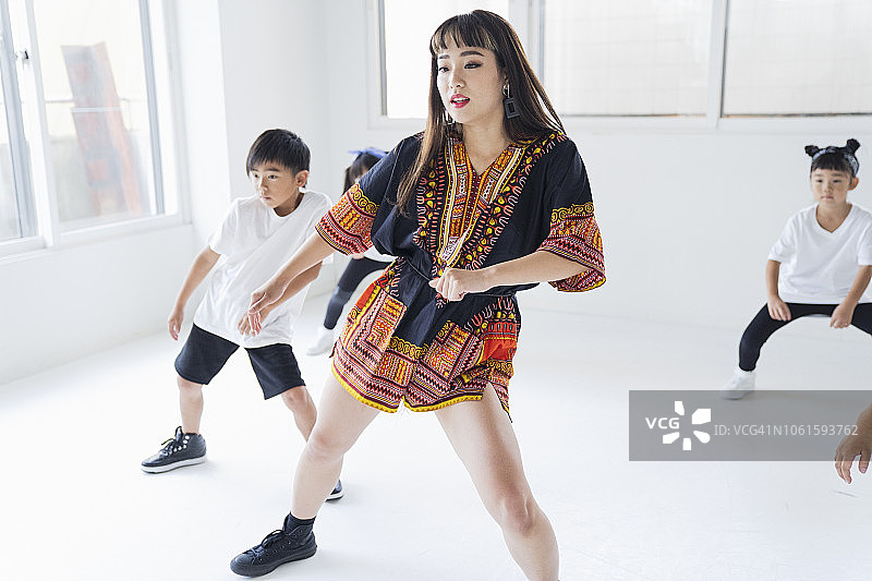 小嘻哈舞者向年轻女老师学习舞蹈。图片素材