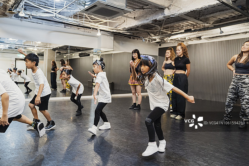 嘻哈舞者与年轻女教师在舞蹈工作室跳舞图片素材