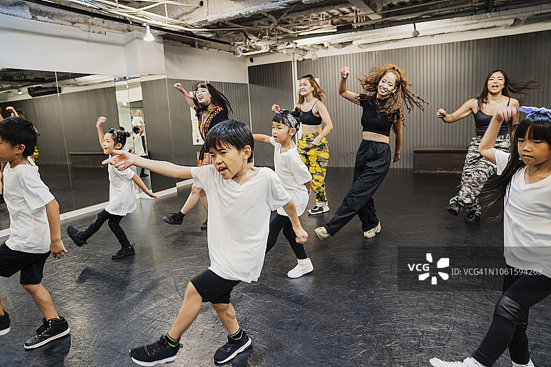 嘻哈舞者与年轻女教师在舞蹈工作室跳舞图片素材