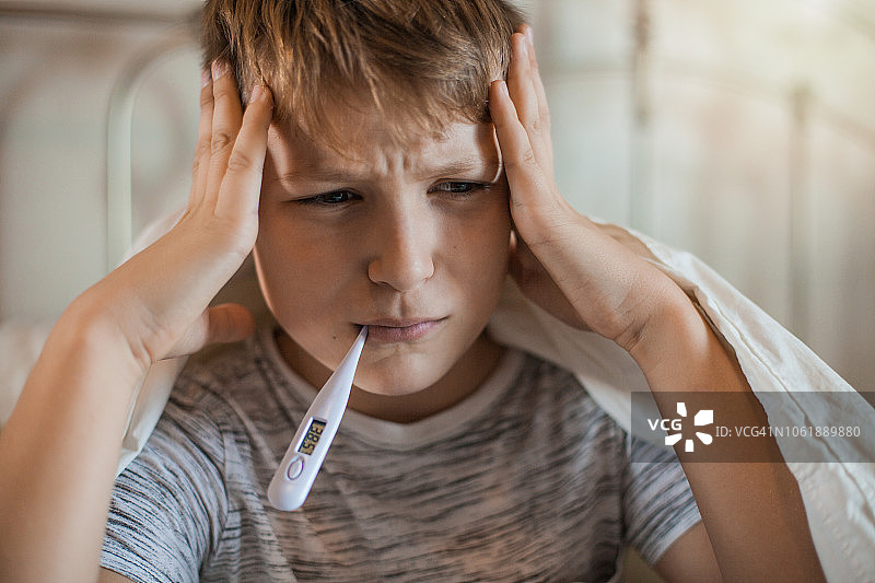 嘴里含着体温计的男孩图片素材