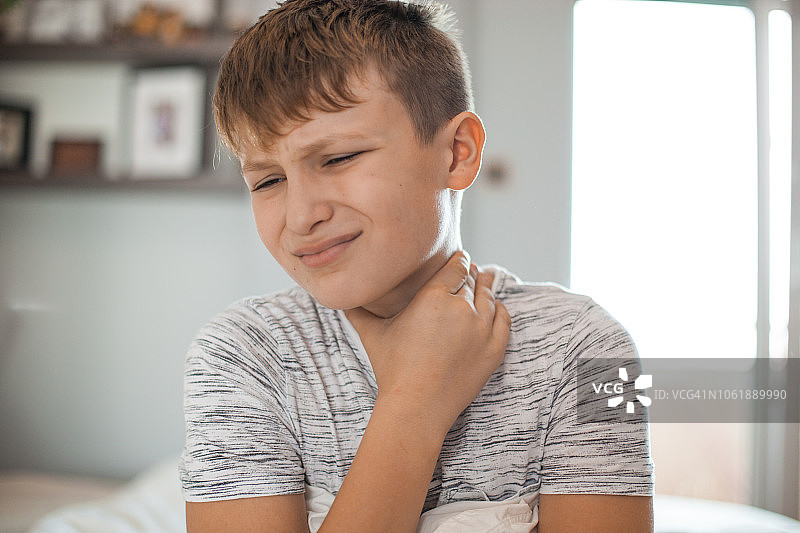 嗓子疼 - 男孩捂着脖子，表情痛苦图片素材