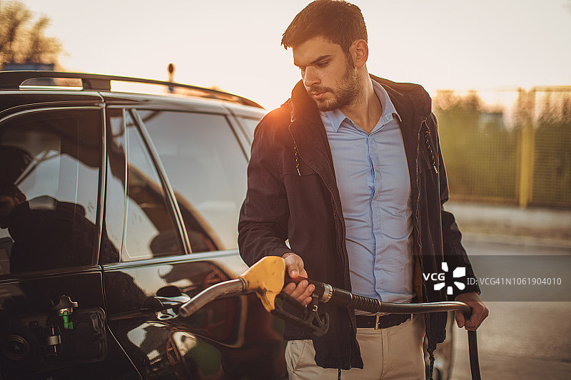 男子给汽车油箱加油图片素材