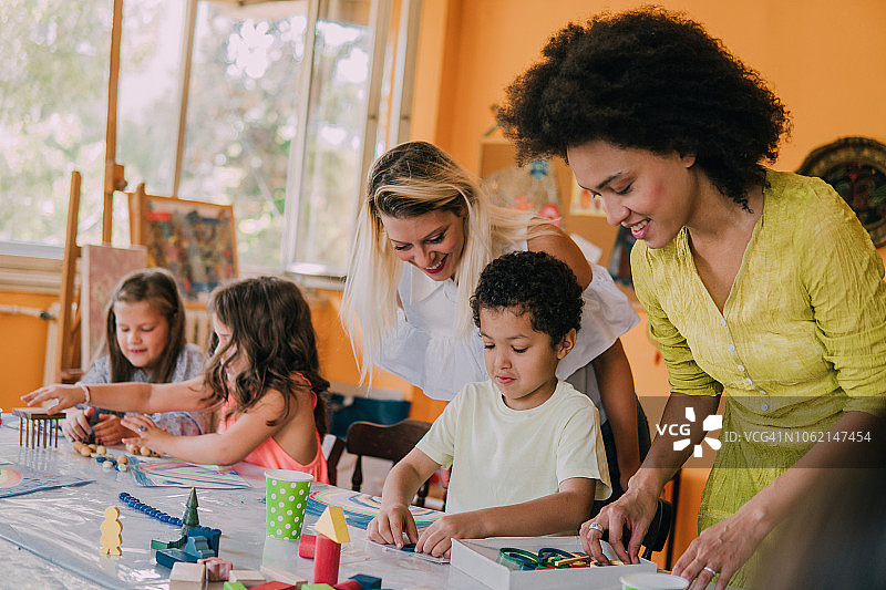 快乐的美术老师看着学生图片素材