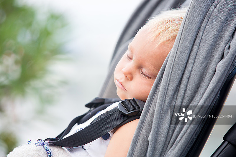 在婴儿车里睡觉的可爱男婴，夏季图片素材