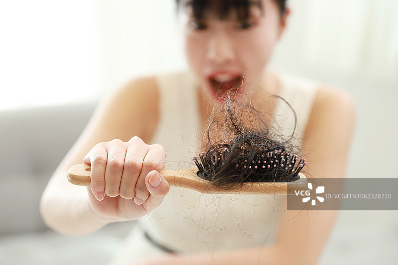 表情焦虑的女人拿着发刷图片素材