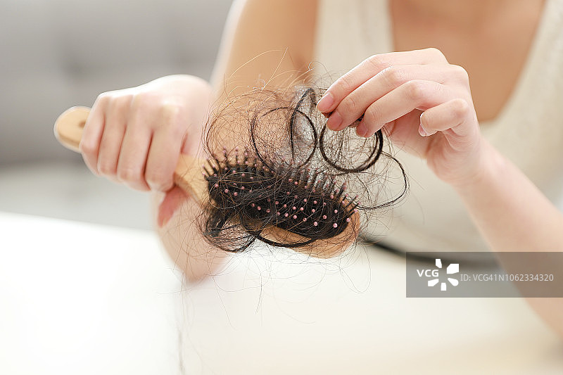 手持掉发梳子的女人特写图片素材