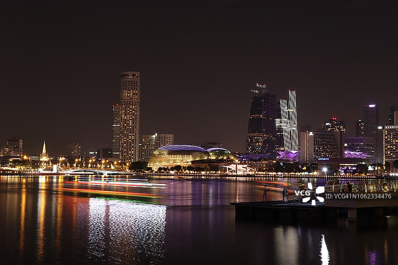滨海湾夜景：彩色游船的光轨和水面倒影图片素材