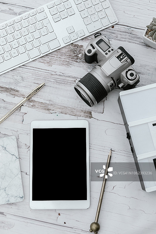 摄影师桌面，有相机、数位板、铅笔和电脑俯视图图片素材