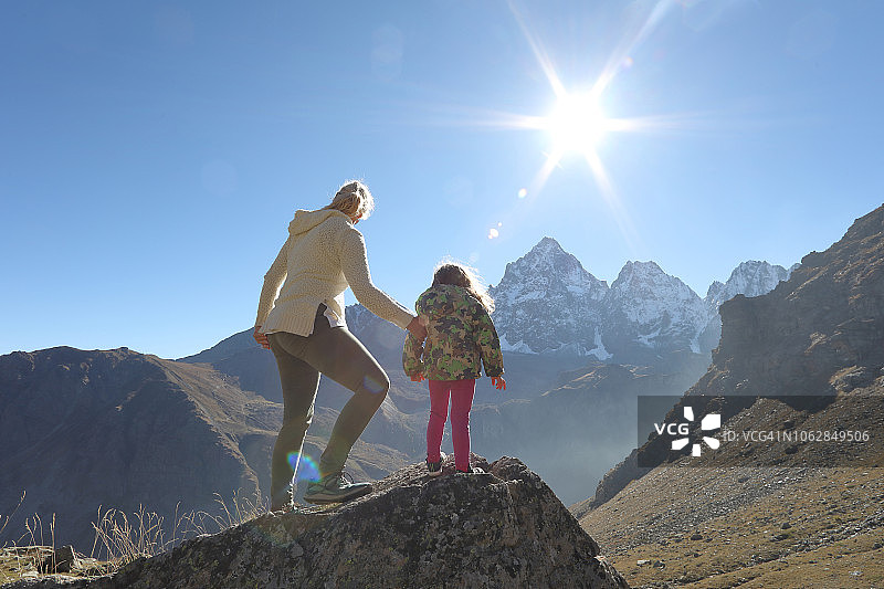 母亲和女儿一起登上山脊图片素材