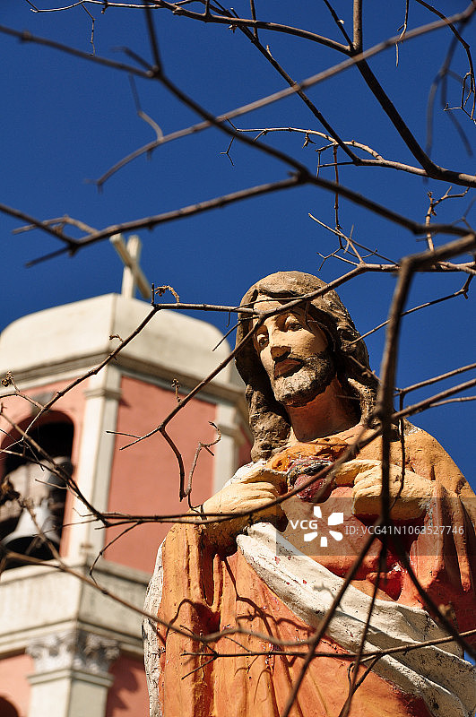 耶稣基督雕像，背景是教堂钟楼图片素材