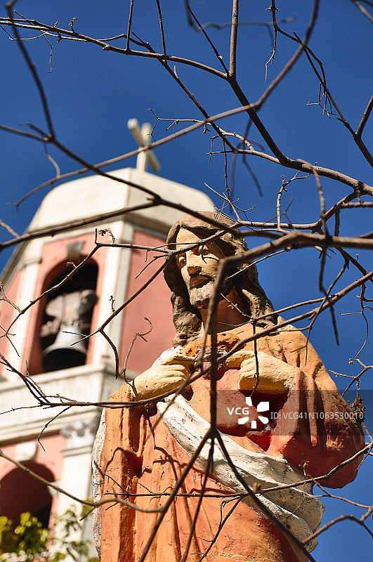 耶稣基督雕像，背景是教堂钟楼图片素材