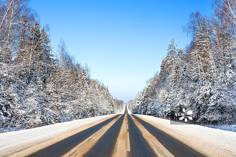 沥青路和森林的冬季景观图片素材