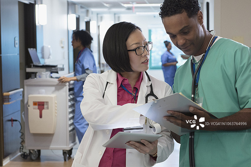 亚洲医生与护士交谈并使用平板电脑图片素材