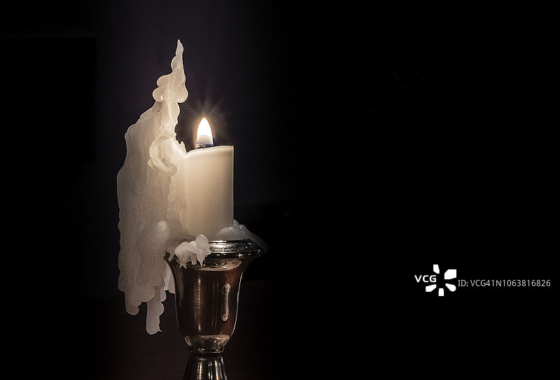 融化蜡烛的银色烛台静物图片素材