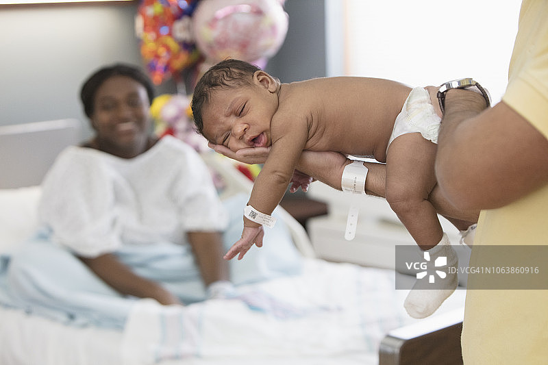 在父亲臂弯中熟睡的新生儿宝宝图片素材