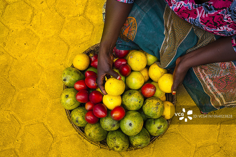 在非洲拿着装有热带水果的篮子的女人图片素材