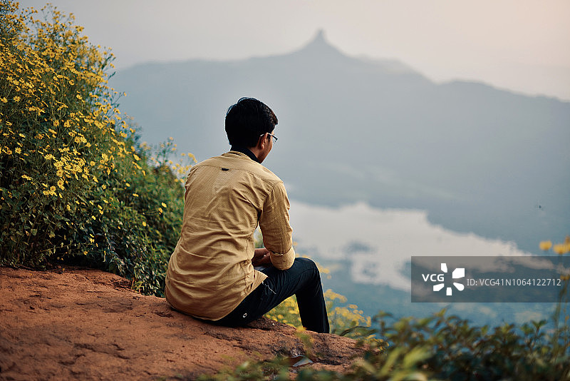 坐着看山景的青少年男孩图片素材