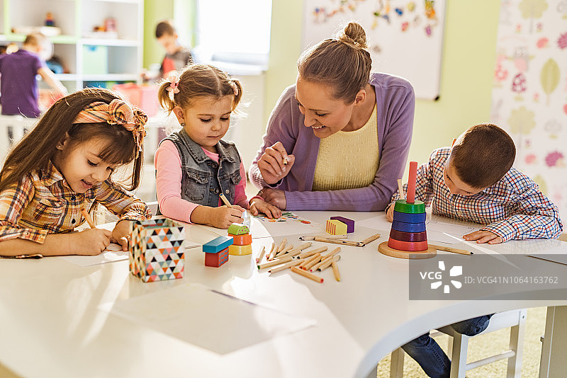 快乐的女老师教孩子们在幼儿园画画图片素材