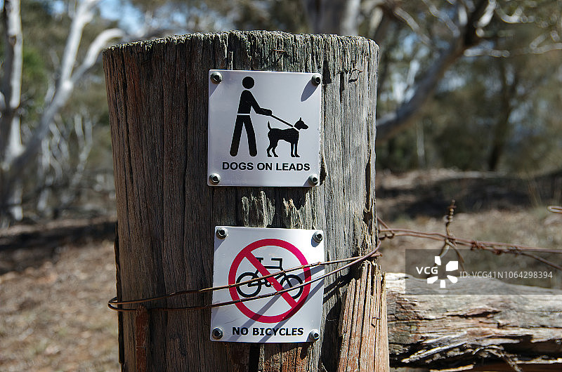 澳大利亚首都领地马朱拉山自然保护区木栅栏上的“禁止自行车”和“牵狗”标志图片素材