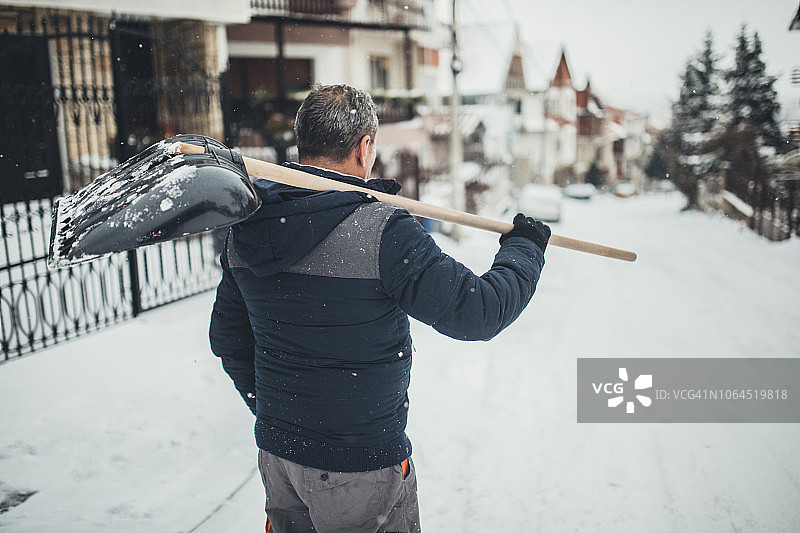男人在冬天清洁人行道图片素材