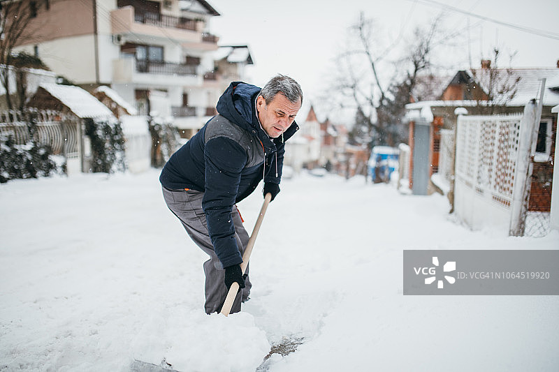 男人在冬天清洁人行道图片素材