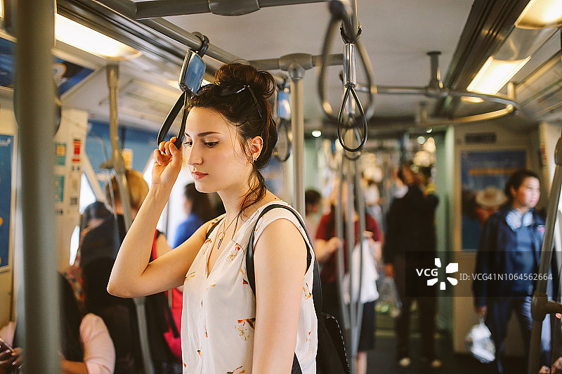 在曼谷地铁中疲惫站立的年轻女游客图片素材