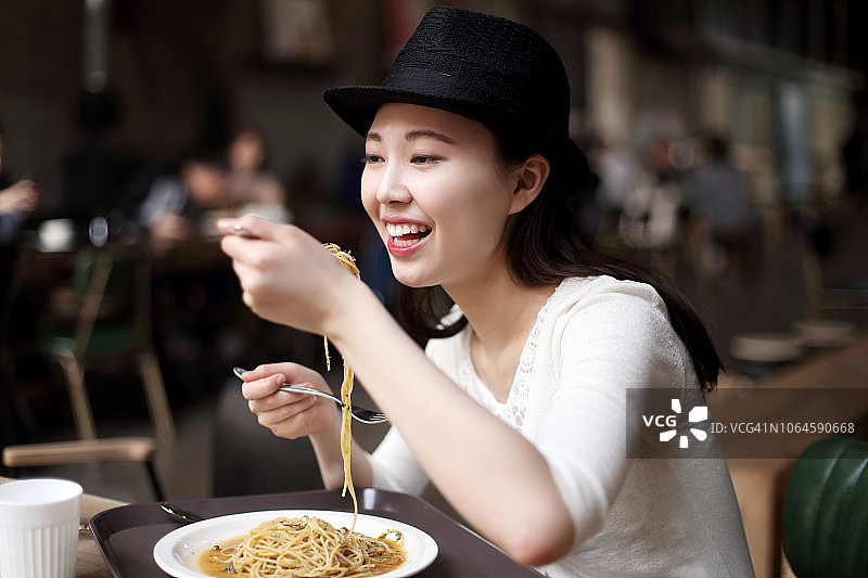 在餐厅吃意大利面的女人图片素材