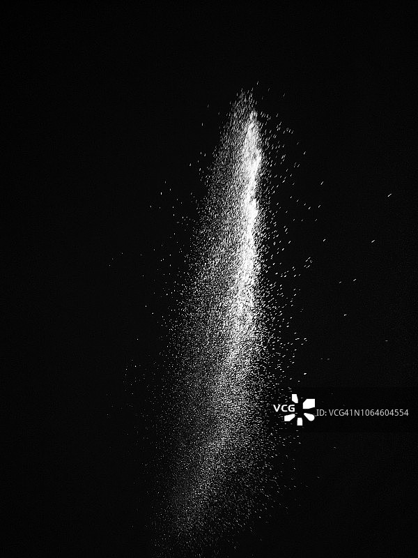 白色粉末粒子云在黑色背景上的冲击爆炸图片素材