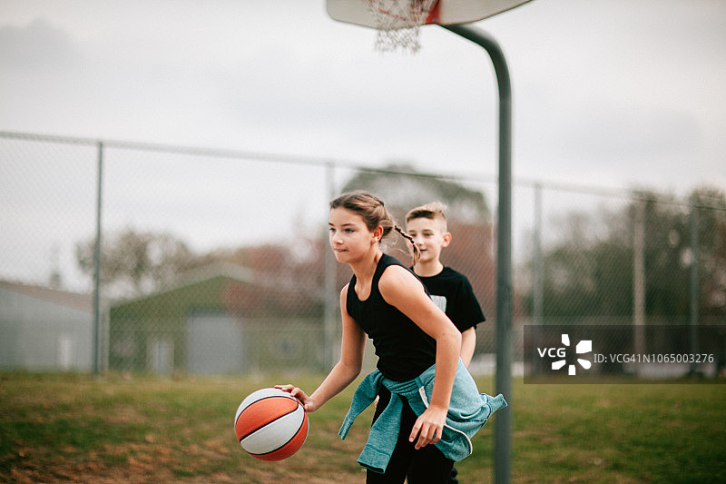 青少年男女在操场上打篮球图片素材
