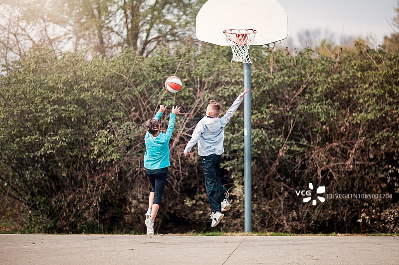 青少年男女在操场上打篮球图片素材