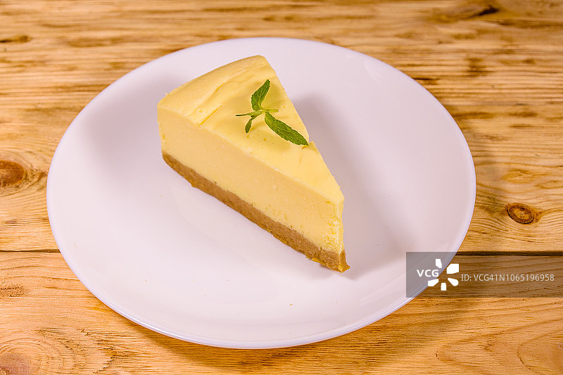 木桌上的纽约芝士蛋糕白盘图片素材