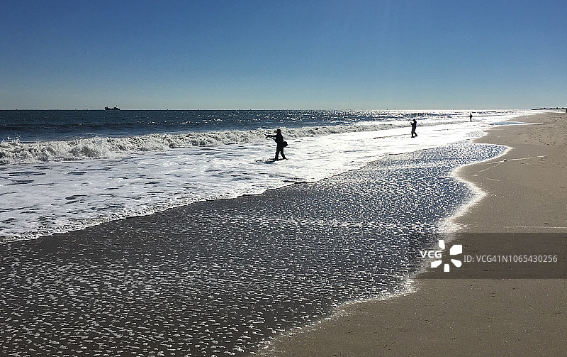 在新泽西州海滩上冲浪钓鱼的男人图片素材