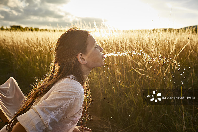 在乡村景观中吐水的女孩图片素材
