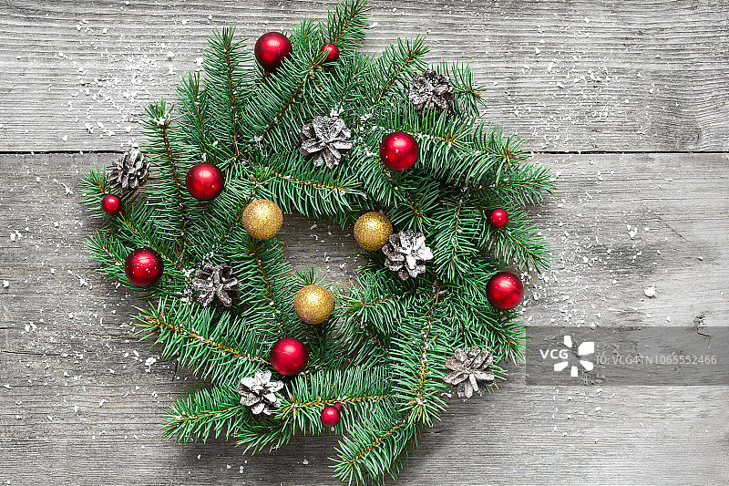 圣诞节或新年花圈与装饰在覆盖着雪的乡村木桌上，俯视图图片素材